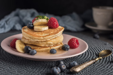 Delicious american pancakes with berries, banana and syrup. Horizontal