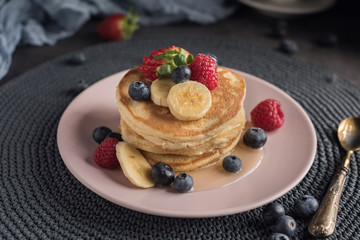 Delicious american pancakes with berries, banana and syrup. Horizontal