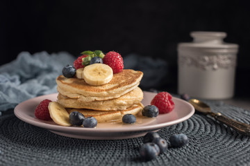 Delicious american pancakes with berries, banana and syrup. Horizontal. Copyspace