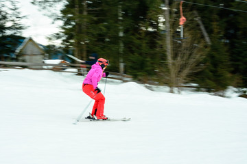 A beautiful woman in red gear learns to ride skiing in the Ukrainian Carpathians