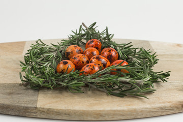 Easter. Easter eggs on a wooden stand with sprigs of rosemary on a white background.