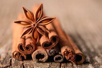 Obraz na płótnie Canvas Anise stars with cinnamon on wooden background - Image