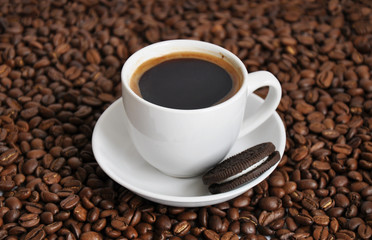 cup of coffee and cookie with beans background