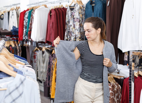 Woman trying blouse clothing boutique