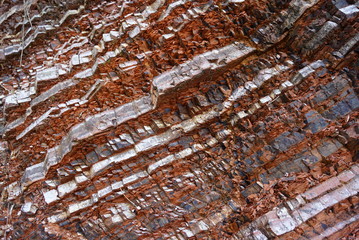 Alternating layers of silver and black with bright red rock.