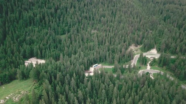 Forward drone shot over the alps in south Tyrol, Italy, showing a curvy road with cars passing