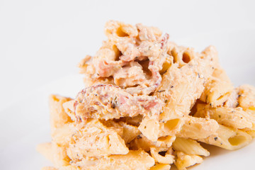 Pasta - penne with cream sauce with bacon on a plate