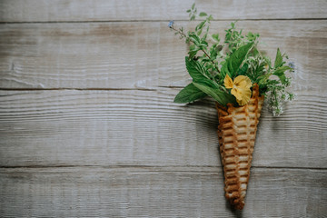 Waffle cone with spring flowers inside with copy space.