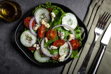 Fresh green salad with blue cheese, onions and cherry tomatoes
