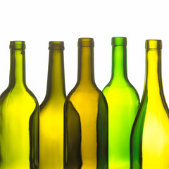 GROUP OF FIVE GREEN AND BROWN WINE BOTTLES ON WHITE BACKGROUND