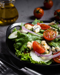 Fresh green salad with blue cheese, onions and cherry tomatoes