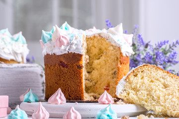 Studio shot of decorated Easter on a white table.  One Easter is cut and an appetizing morsel lies on a white wooden round board.