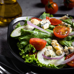 Fresh green salad with blue cheese, onions and cherry tomatoes