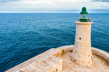Green Lighthouse in the Grand Harbour in Valletta city - capital of Malta. Malta island. Mediterranean sea