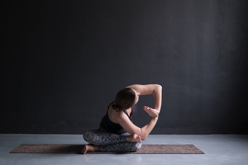 Fototapeta na wymiar Womanl working out, doing yoga exercise on floor twisted agnistambhasana