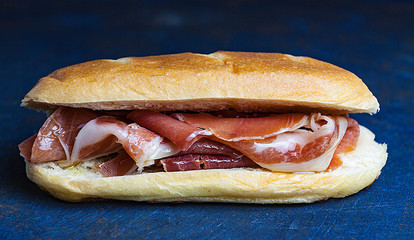 BOCADILLO DE JAMON SERRANO TRADICIONAL AISLADO SOBRE FONDO OSCURO