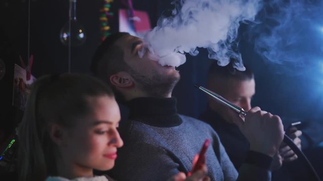 Friends smoking hookah in the bar
