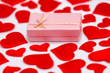 High Angle View of a Pink Gift Box Surrounded by Scattered Hearts on White Background. St. Valentines Day Concept.