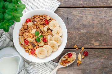 Chocolate granola in the bowl on rustic wooden background with copy space