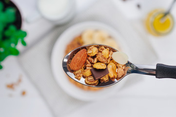 Closeup of spoon with chocolate granola with almonds