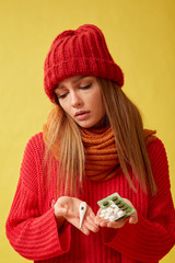 Sick girl holding a medical thermometer and pills. Image on yellow background