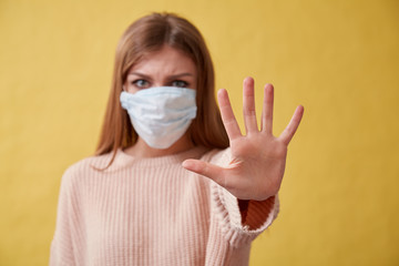 Young ill woman on isolated background. Girl in medical mask.