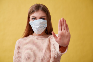 Young ill woman on isolated background. Girl in medical mask.