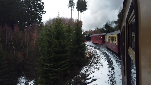 Steam Train going throught a snowy forest in Harz mountains Germany