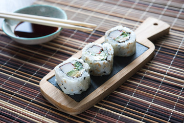 table with sushi with chopsticks and bowl with soy sauce