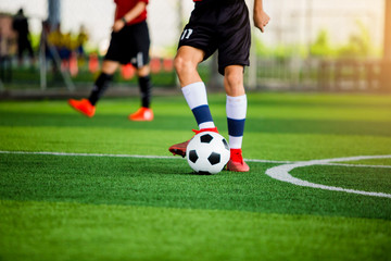 Obraz premium Blurry ball after soccer player shoot it on green artificial turf