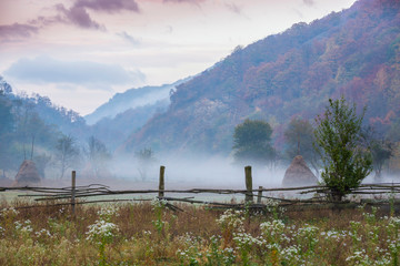 Fototapeta na wymiar Misty autumn scenery in remote rural area in the mountains in Europe