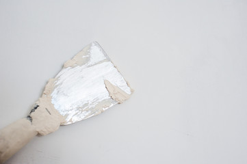 Spatula with putty. The process of applying the paste on the wall