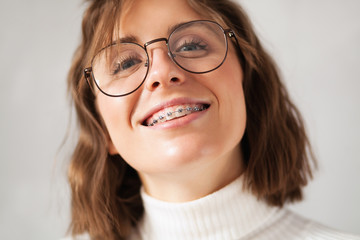 Young beautiful woman with braces - obrazy, fototapety, plakaty
