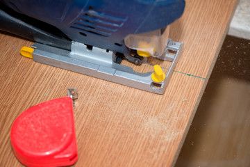 Electrical machine cutting a wooden plank