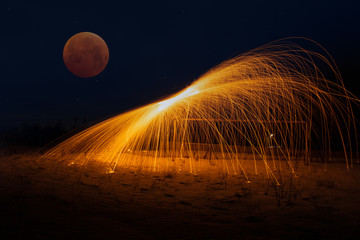Long exposure photography with steel wool and moon eclipse.