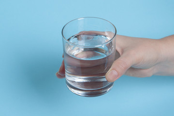 A glass of water in a female hand