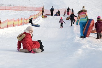 Fototapeta na wymiar Child having fun on snow tube. 