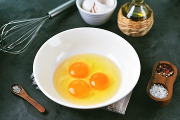 Three raw eggs in a bowl for cooking scrambled eggs.
