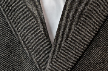 Close up of grey tweed coat with white shirt