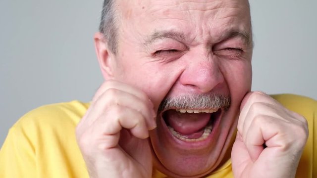 Senior scared man covering his face with hands as he saw a real monster.