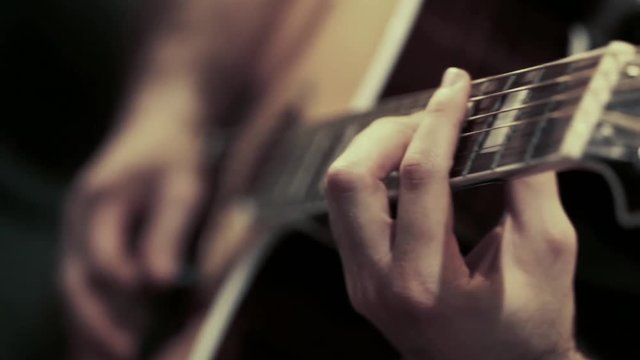 Guitarist plays the guitar during a live performance.