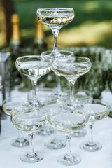Festive aperitif outdoors. A pyramid of glasses of champagne at a wedding party