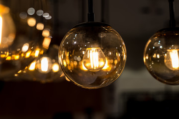 many burning incandescent bulbs hanging on the ceiling