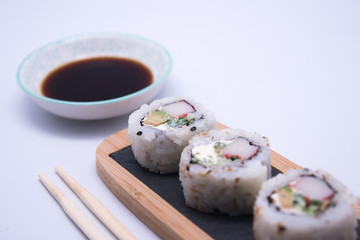 table with sushi and chopsticks with bowl of soy sauce