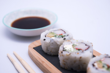 table with sushi and chopsticks with bowl of soy sauce