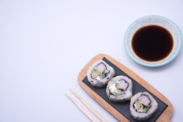 table with sushi and chopsticks with bowl of soy sauce