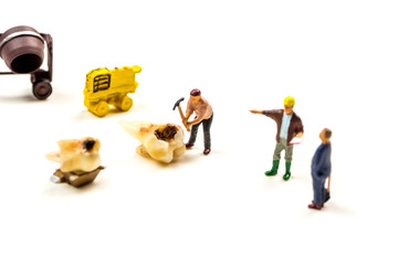 little miniature figurines fixing the problem with big caries on milk tooth molar