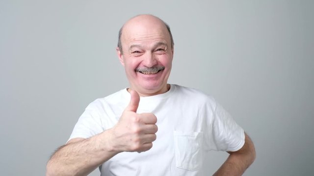 Man trying to make a desicion making good or bad sign.