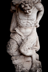 Fototapeta na wymiar Antique statue of Pan (Faunus in Roman mythology). God of the wild, nature and rustic music. He has the hindquarters, legs, and horns of a goat.