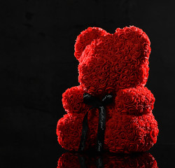 Red bear of roses present gift for valentines day or woman birthday on dark - obrazy, fototapety, plakaty